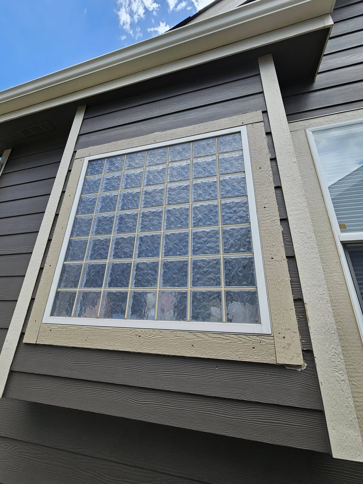 Window with white trim on dark siding